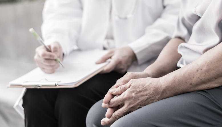 A doctor and patient discuss the findings of a chart while sitting down. 