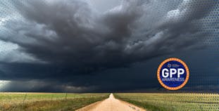 A road stretches into the distance with dark storm clouds overhead, with the GPP Awareness logo.