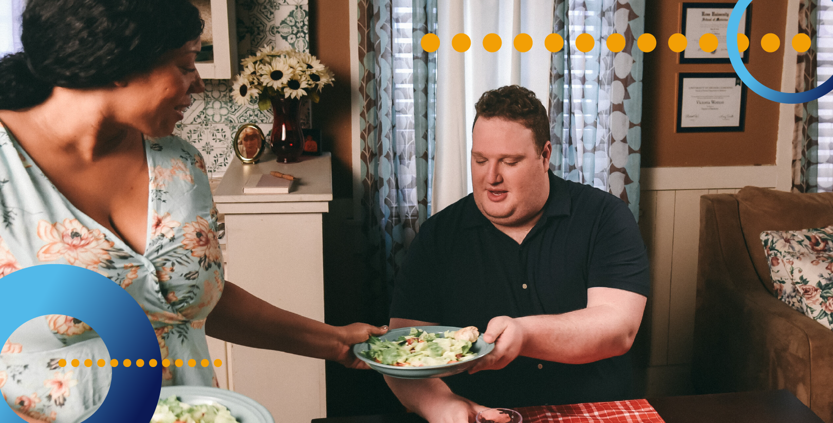A woman hands a man who is sitting at a table food.