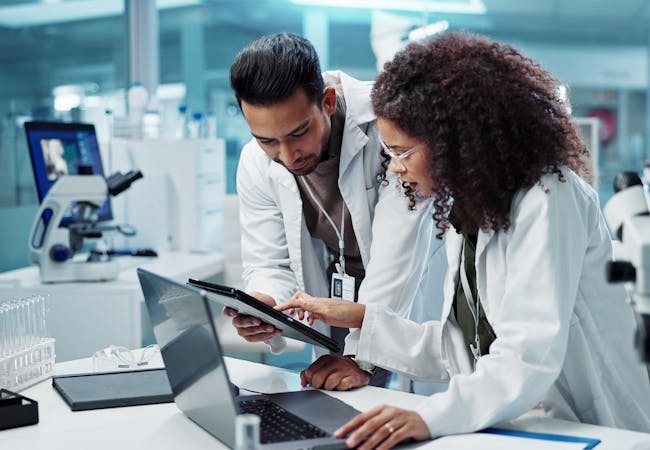 Two researchers review results in a lab.