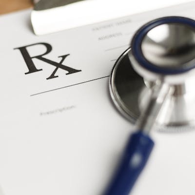 Prescription paper on a clipboard with a stethoscope.