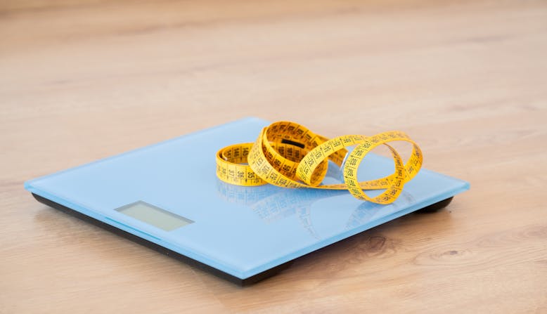 Measuring tape curled up on a scale.