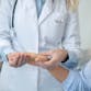 A doctor looking at a patient's hand.