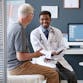 A doctor and a patient in an office smiling.