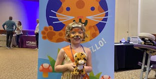 Colette Eide with Spot the leopard stuffy at the Portland Take ACTION event.