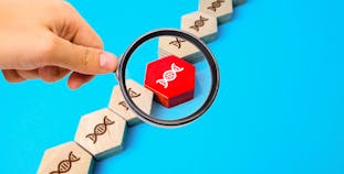 A magnifying glass focuses on a block with a DNA double helix.