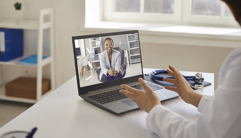 A doctor talks to a patient on the computer. Teledermatology.