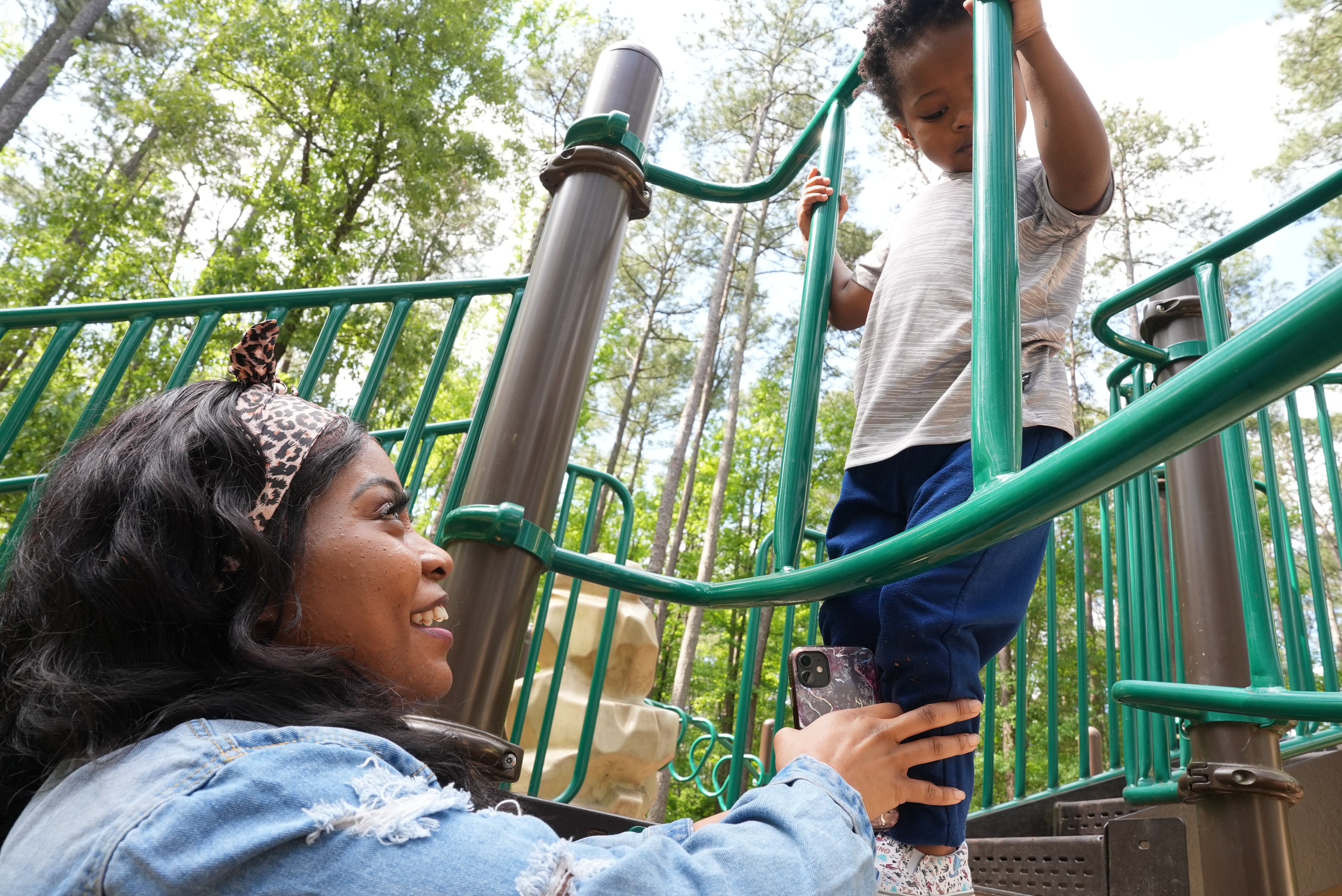 Takieyah and her son on a play structure outside.