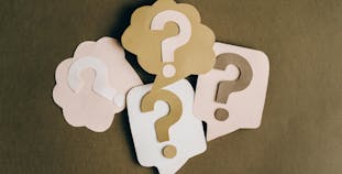 Question marks cut out of paper.