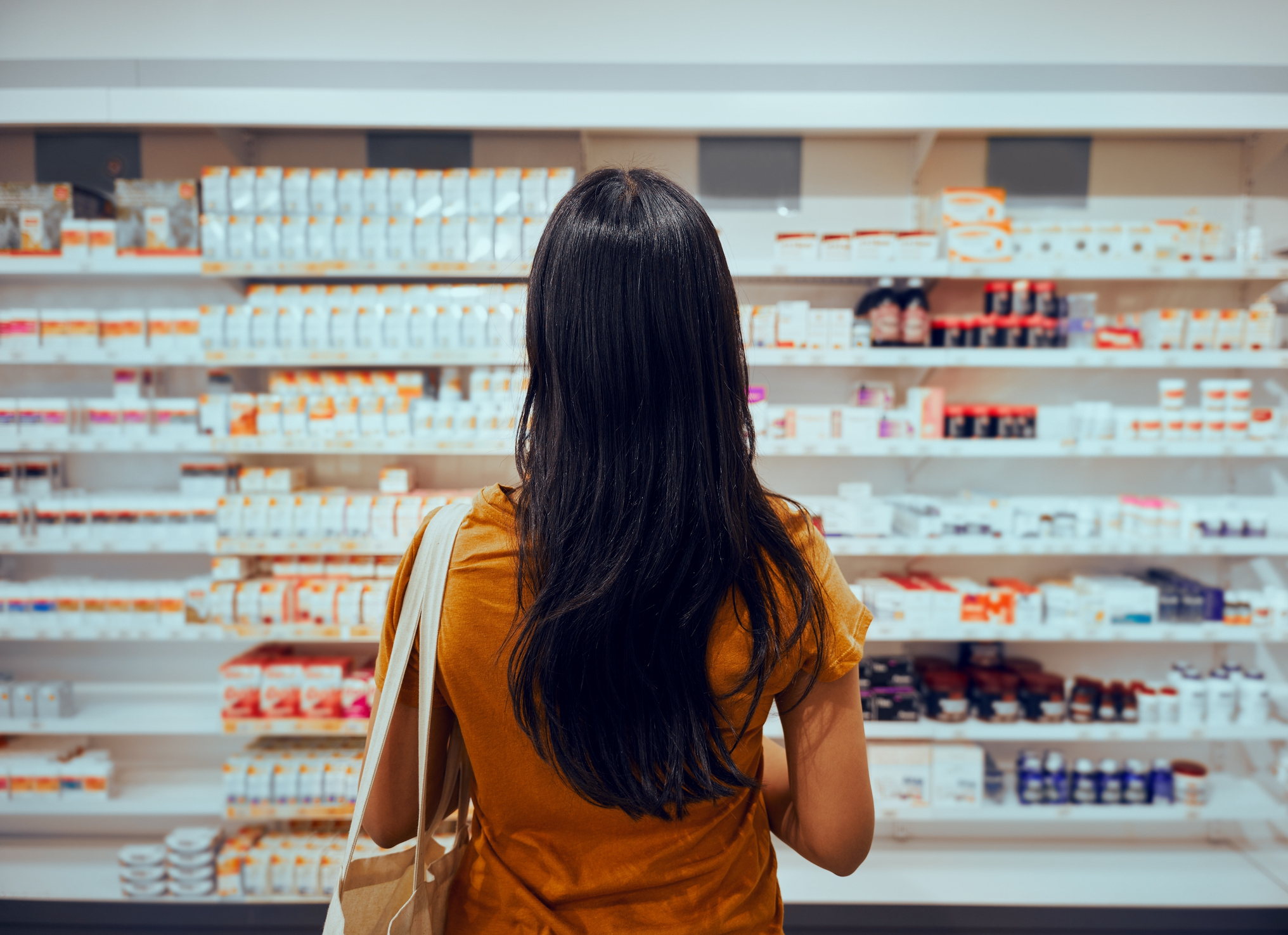 A woman standing in front of a wall of treatment options.