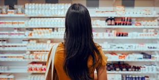 A woman standing in front of a wall of treatment options.