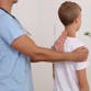 A doctor looking at the spinal position of a child.
