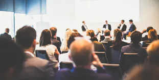 Conference with speakers on stage and a full audience.