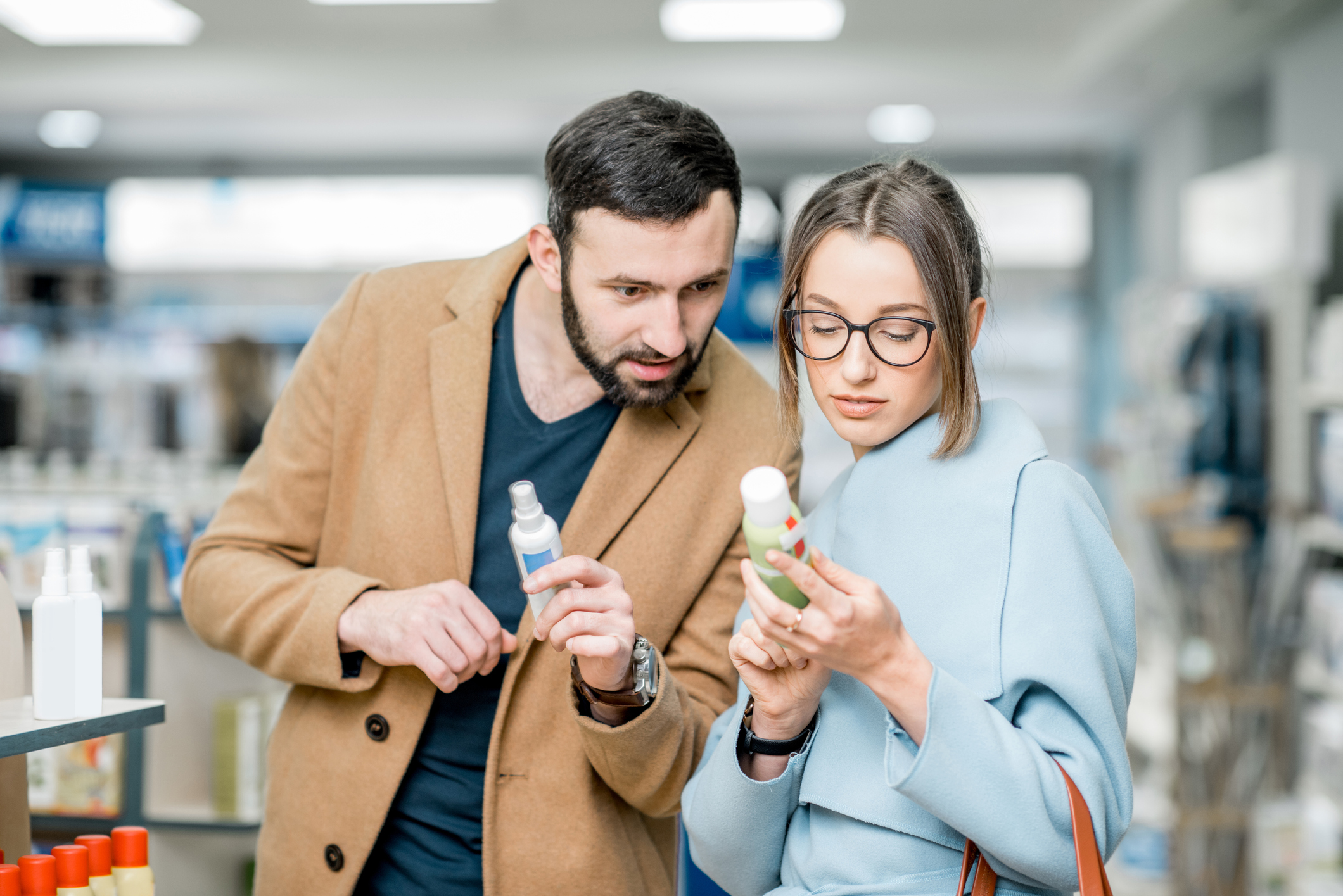 A woman and a man read the label on a over-the-counter product. 