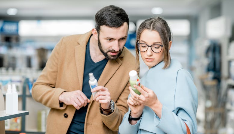 A woman and a man read the label on a over-the-counter product.