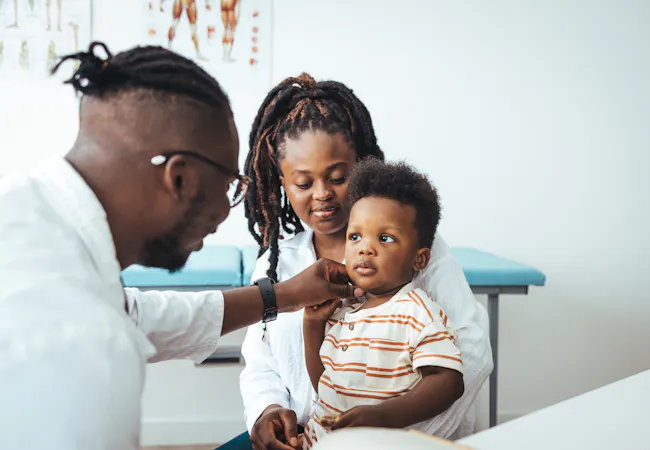 A mom and boy visit a doctor's office.