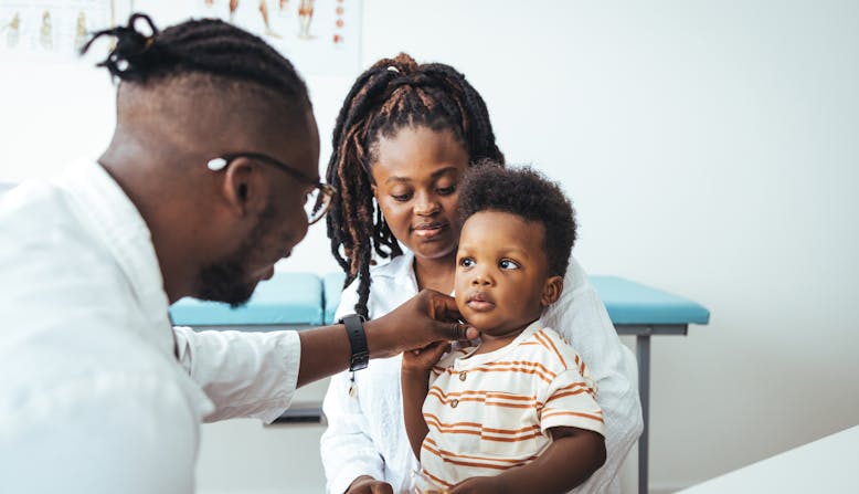 A mom and boy visit a doctor's office.
