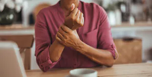 A woman holds her wrist in pain.