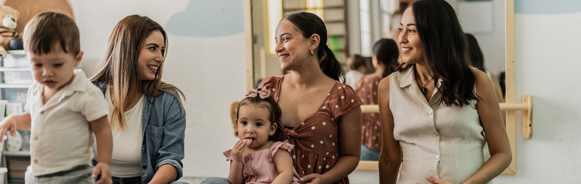 Mothers talking and holding their children.