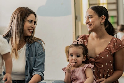 Mothers talking and holding their children.