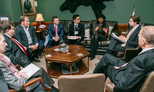 A group of advocates sit down and discuss in an office.