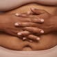 A woman holds her hands over her stomach.