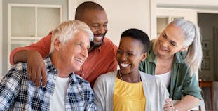 Two couples about the age of people making the change to Medicare gather together smiling.