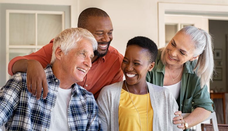 Two couples about the age of people making the change to Medicare gather together smiling.