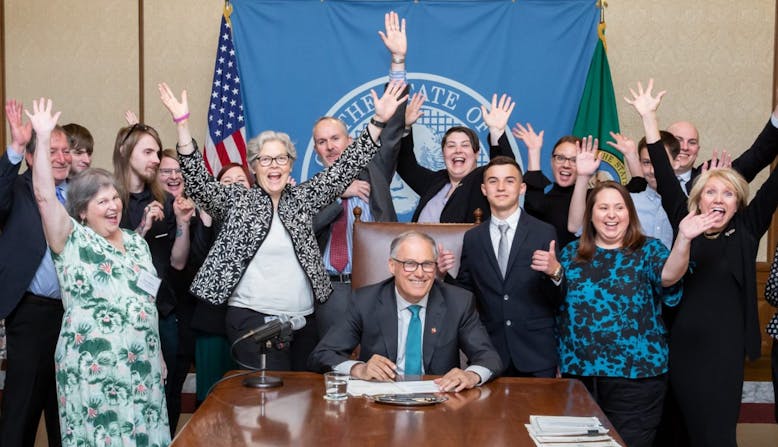 Group of people celebrating at a bill signing.