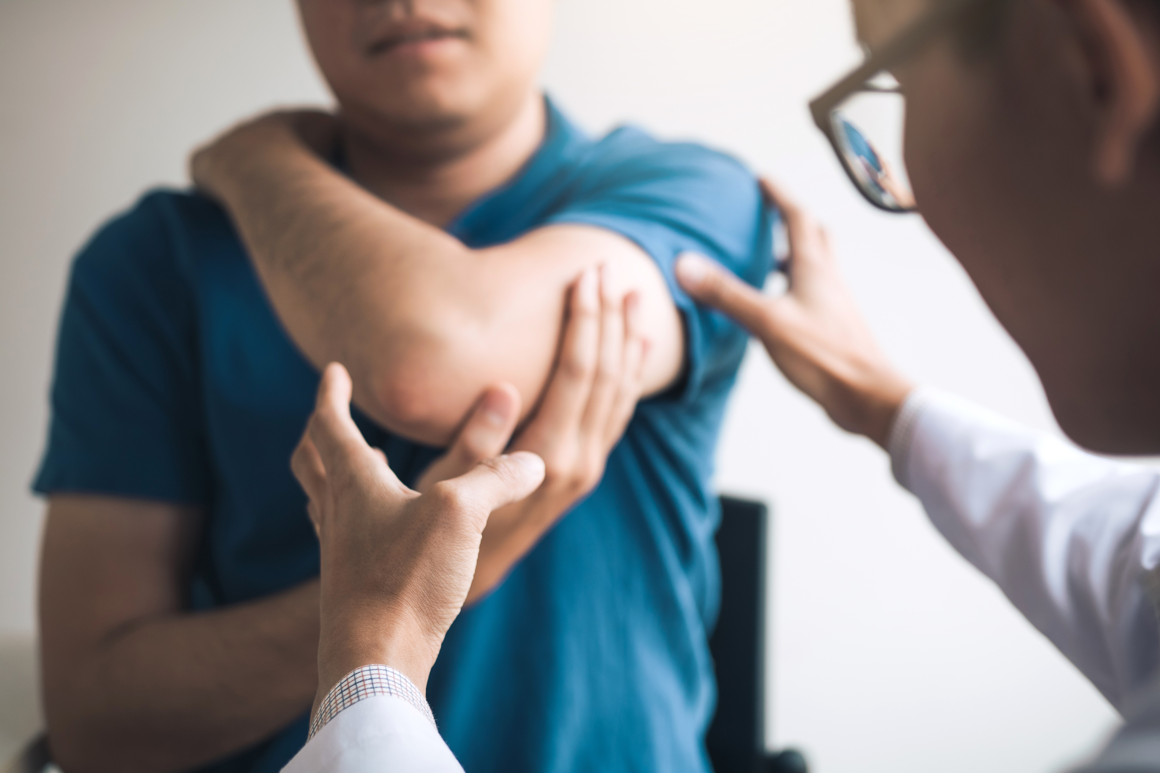 Patient holding arm while doctor examines it