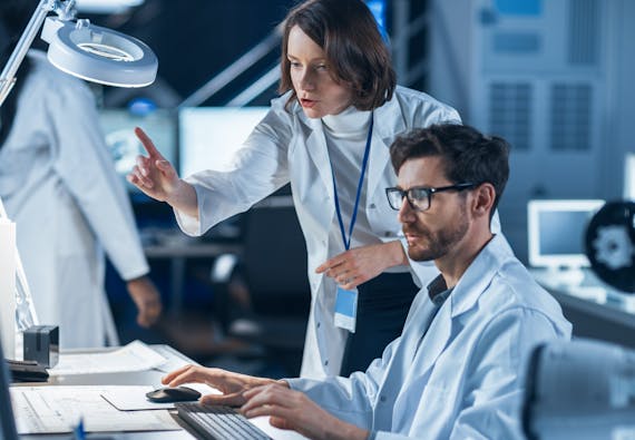 Two people working on a computer in a lab