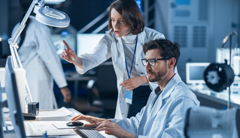 Two people working on a computer in a lab