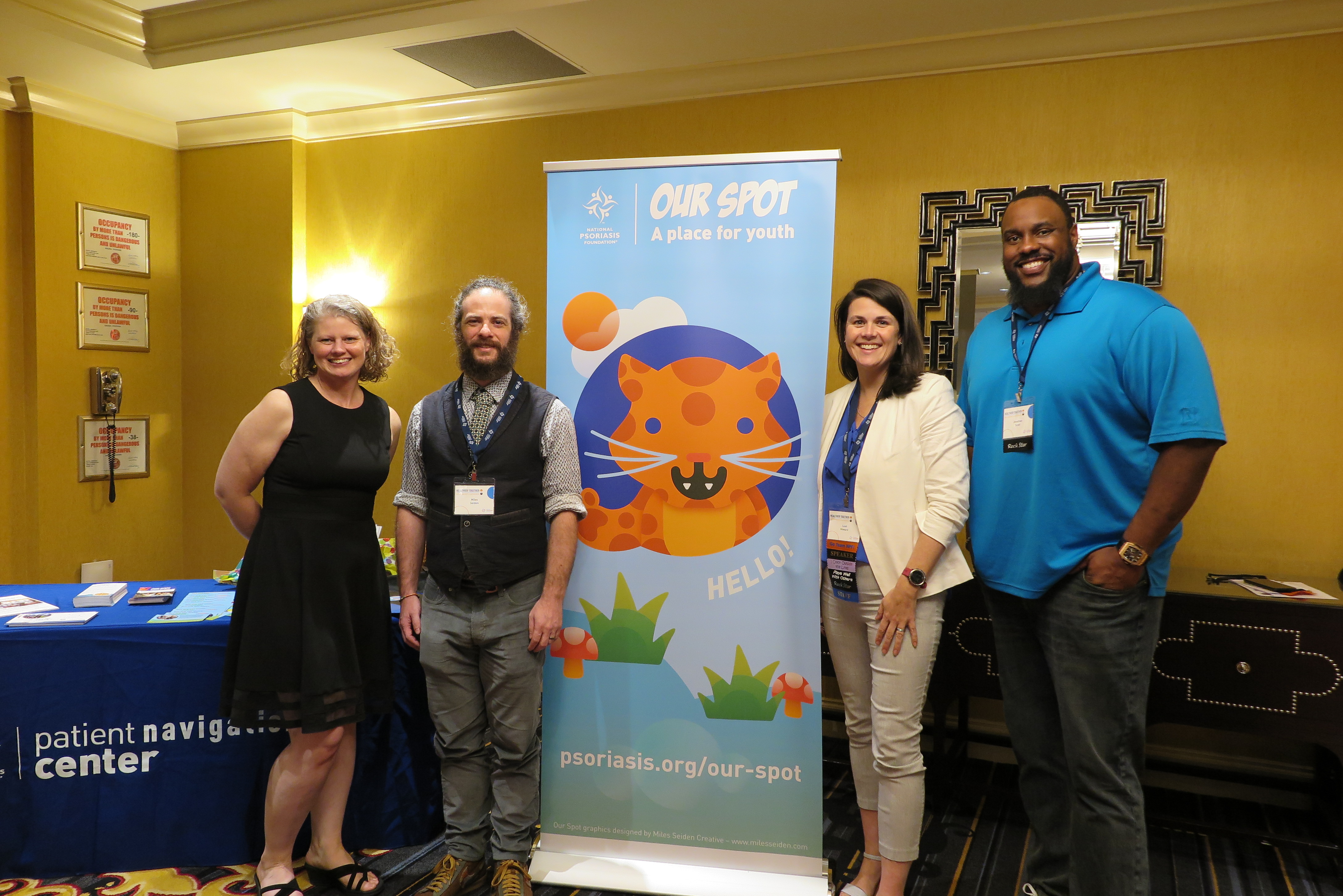 Jaime Lyn Moy, Miles Seiden, Leah Howard, Jonathan Scott standing next to the NPF Our Spot banner at the Healthier Together: Learning for All Ages conference.