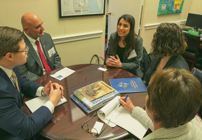 NPF Advocates sit around a table in an office speaking to a representative.