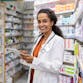 Portrait of smiling young pharmacist working in drugstore with digital tablet.