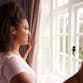 A woman looks out the window smiling.