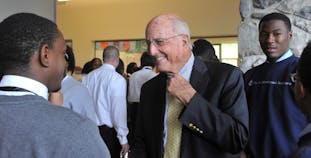 James Walton Sr. at an event, smiling and conversing.