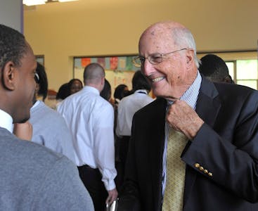 James Walton Sr. at an event, smiling and conversing.