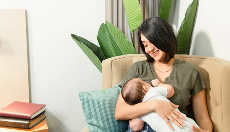 A woman breastfeeds an infant.