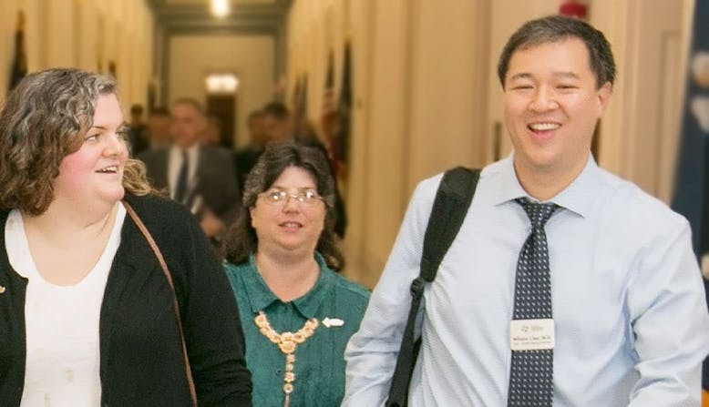 Wilson Liao and advocates walk together in a government building. 