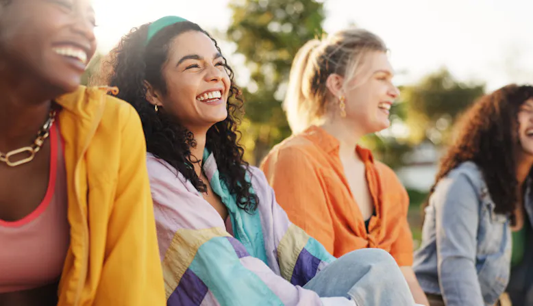 A group of women smiling outside.