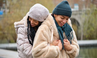 Two women embrace outside in the winter.