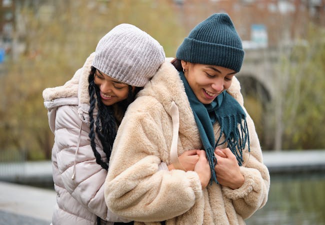 Two women embrace outside in the winter.