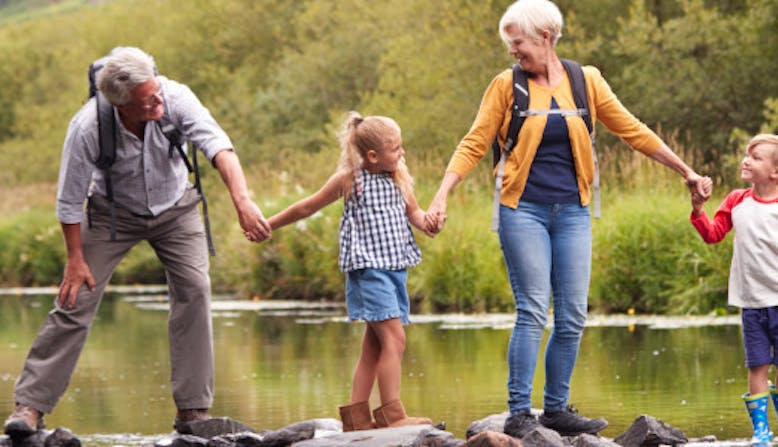 A family hold hands in nature.