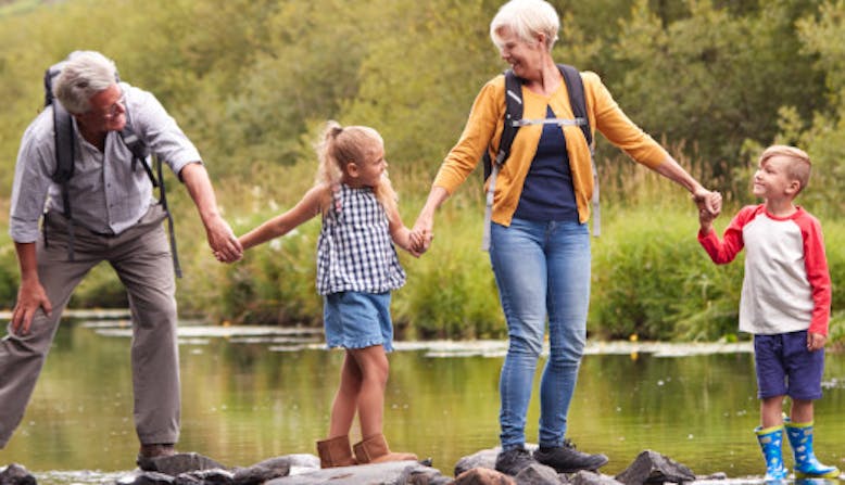 A family hold hands in nature.