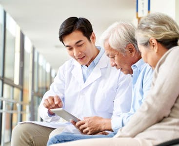 A doctor discusses treatment with a patient and his spouse.