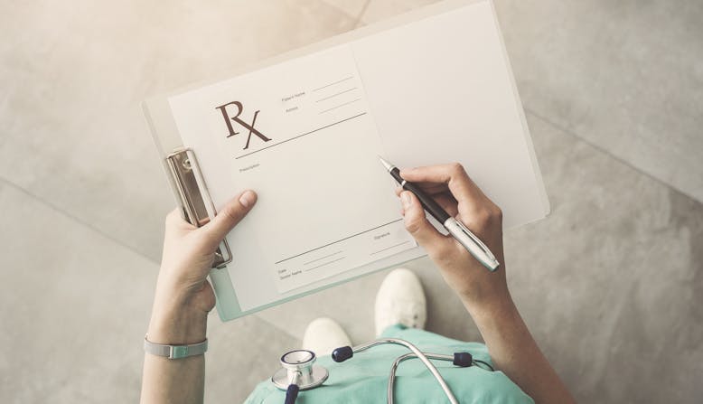 A medical professional holding a clipboard with a prescription form ready to fill out.