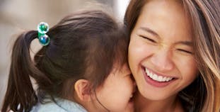 A mother and daughter share an embrace.