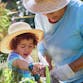 A grandmother and grandchild garden together.