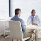 A dermatologist discusses results with a patient in an exam room.